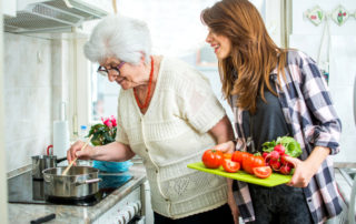 Grandmother and her granddaughter cooking together in kitchen.